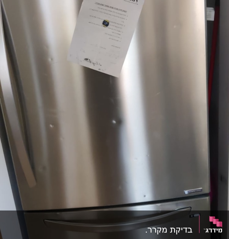 מקרר נירוסטה עם דלת תחתונה ומסמך על הדלת